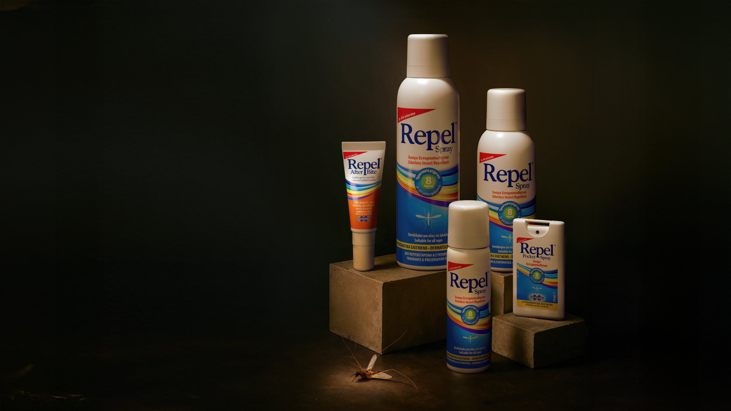 Four Repel insect repellent products are displayed on blocks, with a cockroach on the surface in front of them. The products are in various bottle sizes and designs, all with blue and white labels.